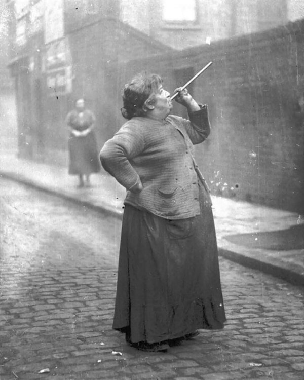 Женщина-будильщик поднимает рабочих на смену, 1940-1950 годы