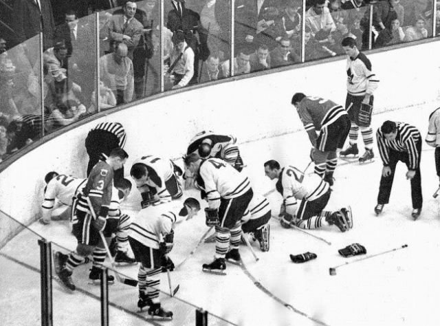 Игроки Toronto Maple Leafs и Chicago Black Hawks ищут потерянную дорогую контактную линзу Джека Эванса. Через месяц Leafs выиграют Кубок Стенли, 1962 г.