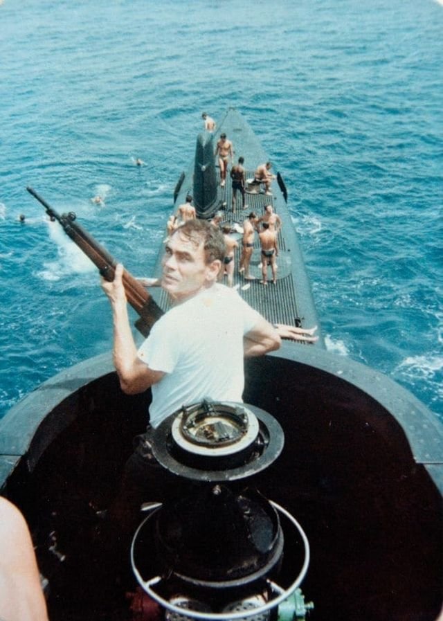 Подводник ВМС Бразилии, вооруженный винтовкой FN49, охраняет своих коллег от акул, январь 1985 года.