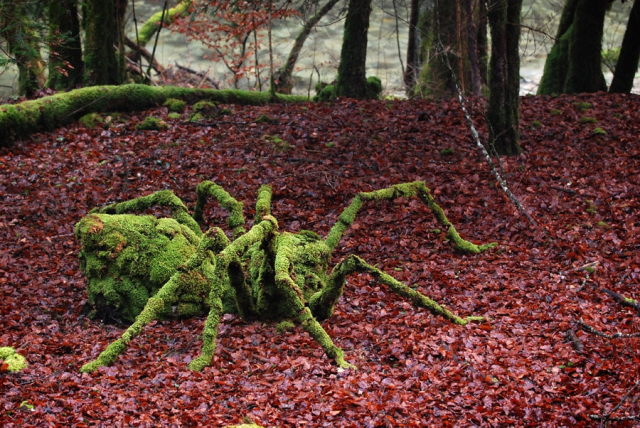 Этот гигантский паук представляет собой аккуратно расположенную коллекцию валунов и ветвей, украшенных мхом