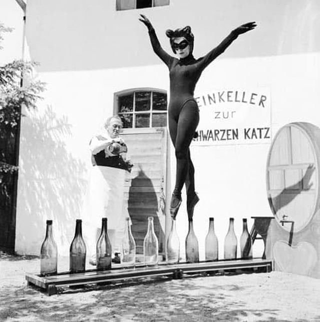 17-летняя Бьянка Пассарге из Гамбурга танцует на винных бутылках в костюме кошки, 1958 г.