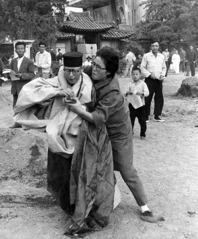 Женщина выхватывает спички у монаха пытающегося совершить самосожжение. Сеул, Южная Корея, 1963 год.