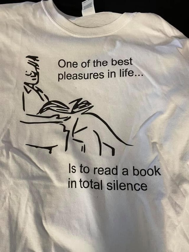 Надпись на футболке: &quot;Одно из главных удовольствий в жизни... Чтение книги в полной тишине&quot;.