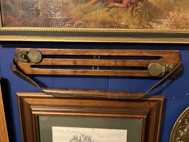 5. Деревянная конструкция длиной около 30 сантиметров с двумя латунными кольцами и ручкой, найдена в пабе в сельской Англии