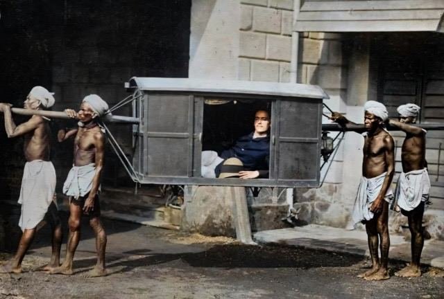 Четверо индийских носильщиков несут западного туриста в паланкине. Индия, 1922 год.