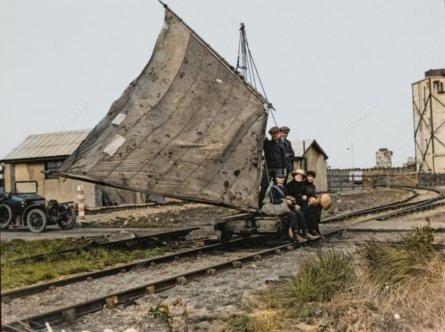 Группа мужчин едет по железнодорожным путям на вагонетке с парусным приводом в Сперн-Хед, Англия, 1922 год.