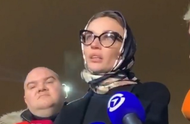 Алена Водонаева в очках и платке дает интервью перед зданием суда
