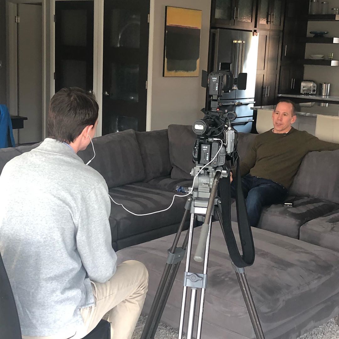 Джефф Гебхарт дает интервью журналисту в команте на диване