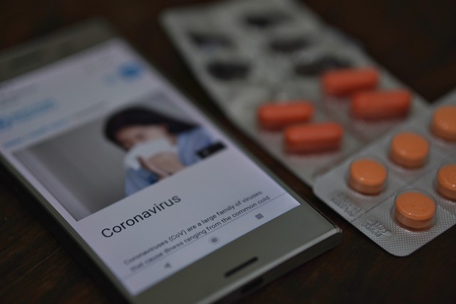 Бэйдж с фотографией и подписью "коронавирус", таблетки в упаковке