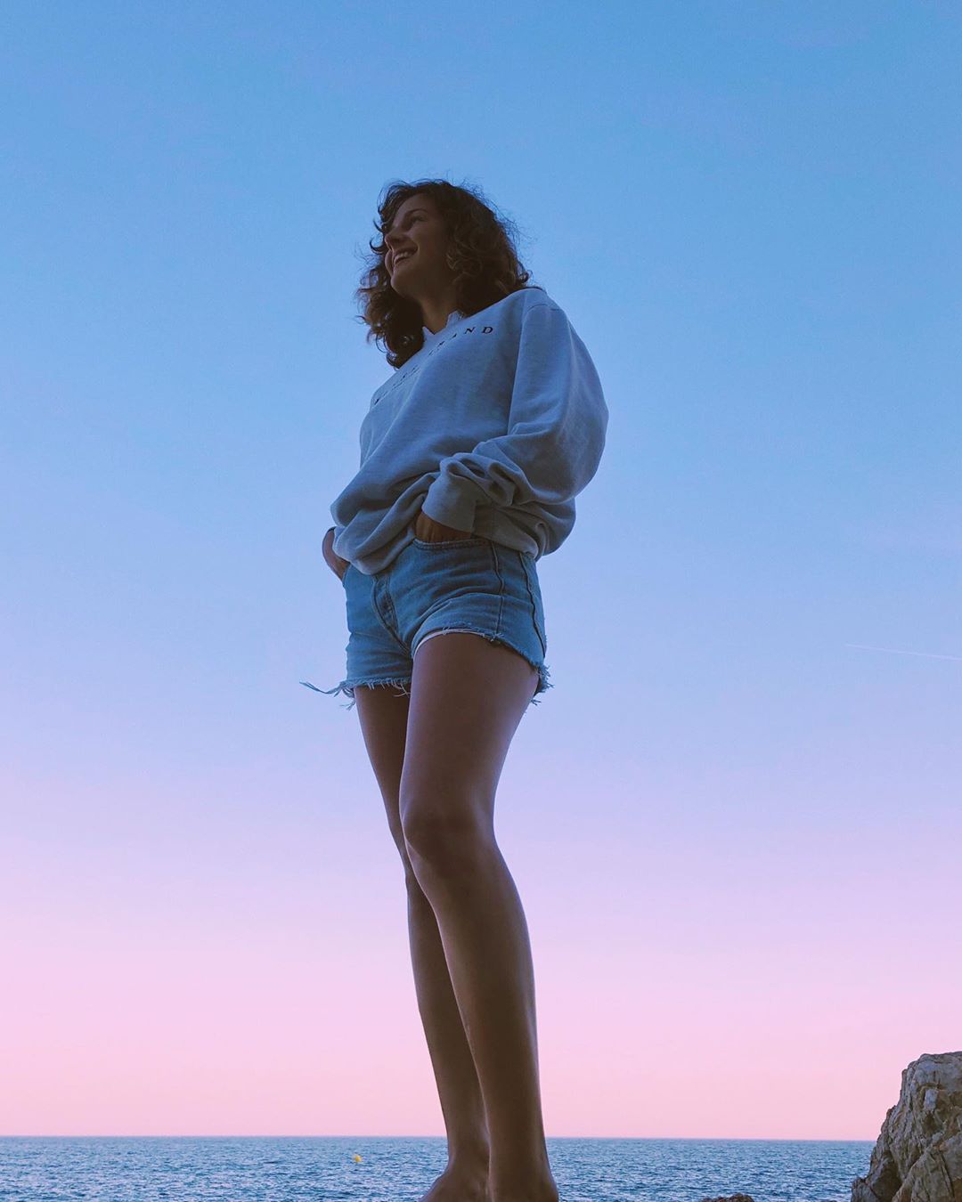 Валерия Демидова позирует на берегу в кофте и джинсовых шортах, показывае ноги