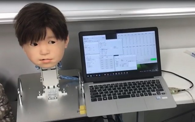 Мальчик с искусственной кожей и ноутбук в лаборатории