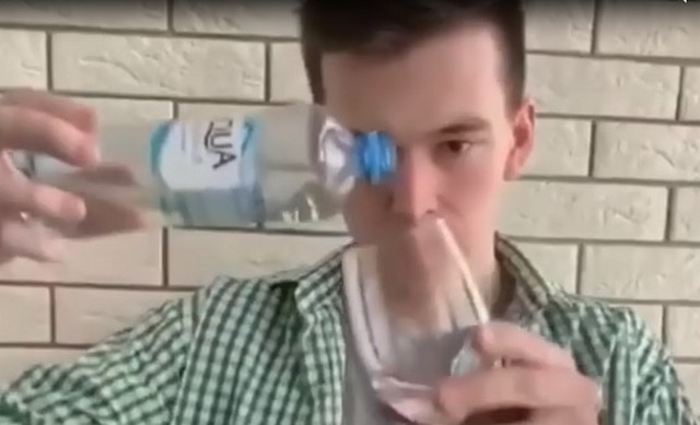 Молодой человек наливает воду в бокал