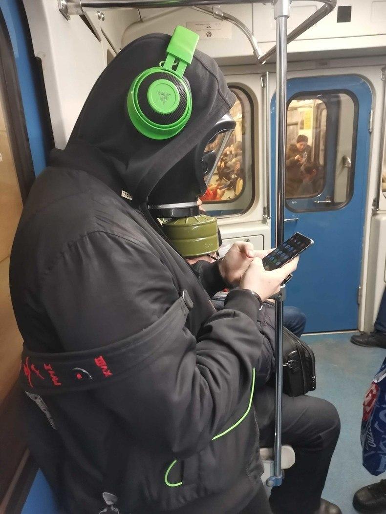 Мужчина в метро с наушниками и противогазе