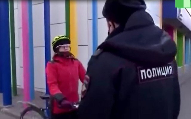 Женщина на велосипеде разговаривает с полицией