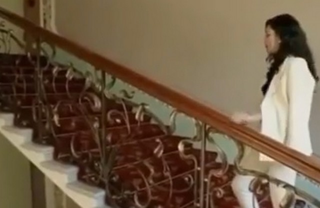 Девушка в белом костюме поднимается по лестнице