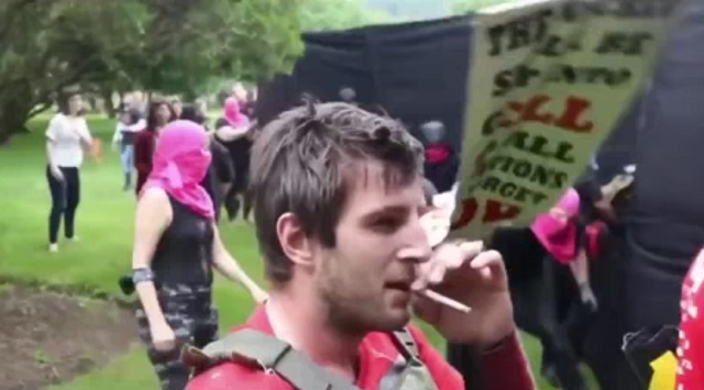 Мужчина курит на митинге