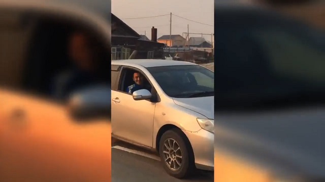 Мужчина улыбается в окне машины