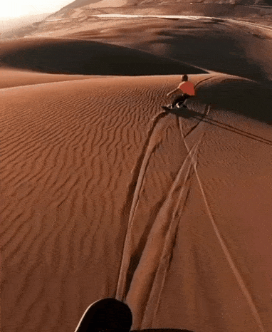 На доске по песочным дюнам