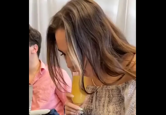 девушка берет бокал в рот