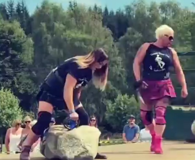 Девушка поднимает камень