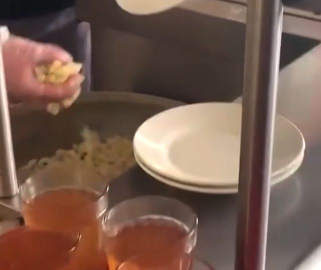 повар накладывал детям еду рукой