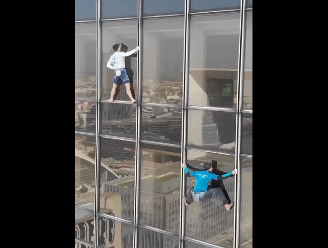Два "человека-паука" взбираются на небоскреб