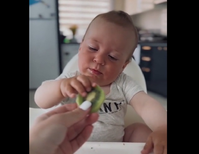 ребенок кушает киви
