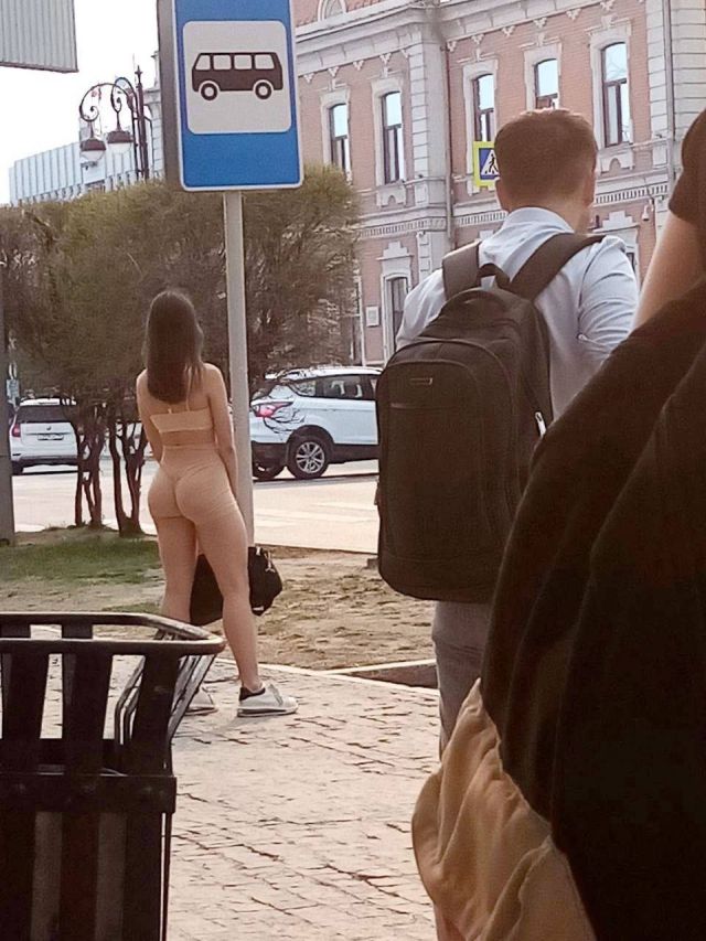 Женщина без лифчика в прозрачной блузке на автобусной остановке