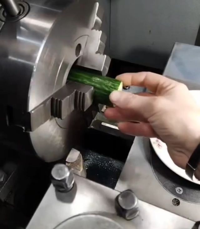 Парень при помощи токарного станка с ЧПУ объединить огурец и морковь