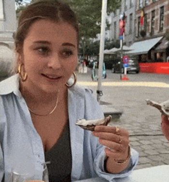 Девушка первый раз пробует устрицу Девушка первый раз пробует устрицу